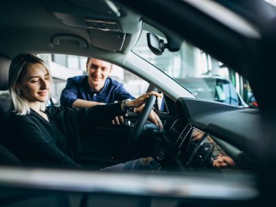 young-woman-with-salesman-carshowroom_1303-16342